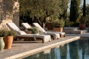 Abords de piscine avec dallage en pierre, transats et plantes méditerranéennes