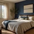 Chambre d'adulte avec mur bleu profond derrière le lit et murs beige sable