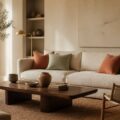 Salon aux murs beige sable avec coussins terracotta et vert sauge