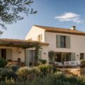 Toit de maison en tuiles de terre cuite vu depuis le jardin sous un ciel bleu avec nuages légers