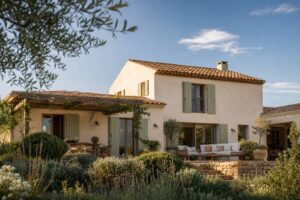 Toit de maison en tuiles de terre cuite vu depuis le jardin sous un ciel bleu avec nuages légers
