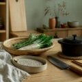 Couteau japonais, casserole en fonte et passoire en bambou sur un plan de travail
