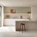 Cuisine contemporaine lumineuse au sol en grès cérame effet béton avec fenêtre et plan de travail