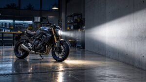 Moto aux feux allumes eclairant un mur dans un atelier sobre